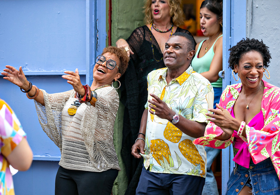 Choco Orta y José Alberto “El Canario” cantan junto a un grupo de personas en una escena de la producción musical de Popular, “Salsa: sabor y evolución”.