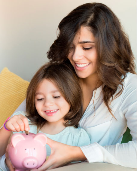 Woman and girl saving in a piggy bank