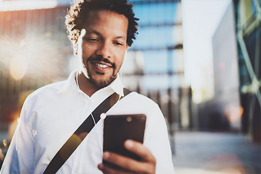  Man walking down the street and looking at his cell phone