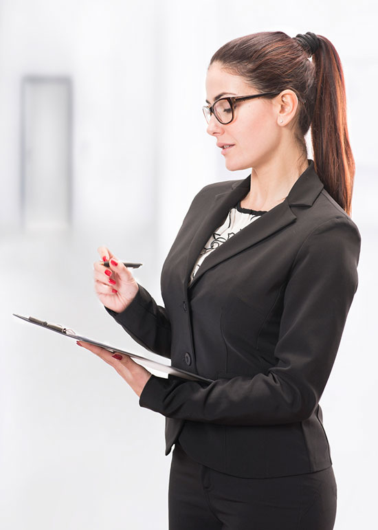 Woman in suit and glasses taking notes